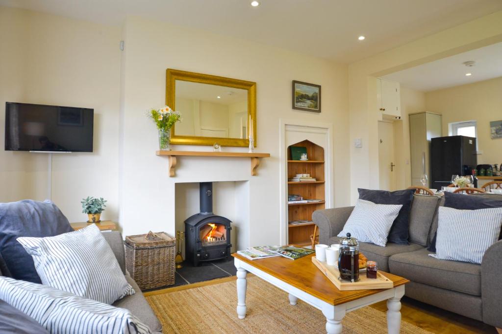 a living room with a fireplace and a couch at Orchard Cottage in Cornhill-on-tweed