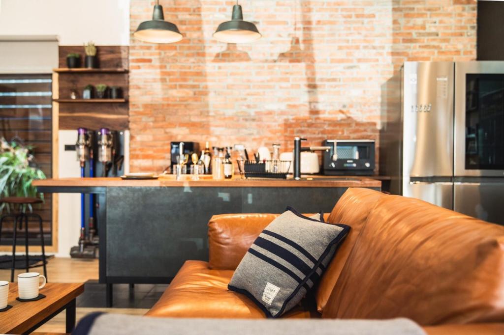 un canapé en cuir brun dans une cuisine avec un bar dans l'établissement Boy apartment -Adult only, à Hualien