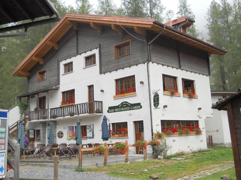 a large white building with flowers in the windows at B&B La Locanda in Macugnaga