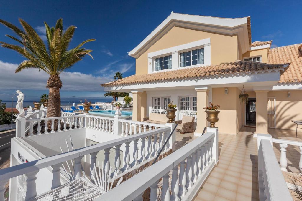 una casa con una valla blanca y una palmera en Villa Mary, en Callao Salvaje