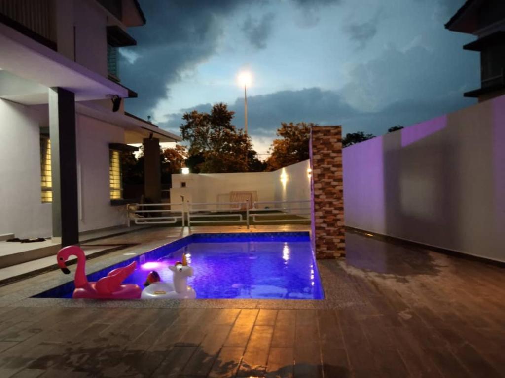 a swimming pool with two toy flamingos in a house at Villa with private Pool and Sauna @ Nilai in Nilai