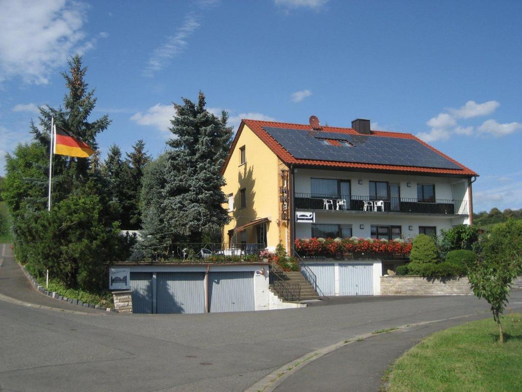 uma casa com uma bandeira ao lado de uma estrada em Gästehaus Hannelore em Geiselwind