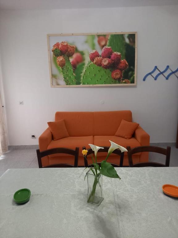 a living room with a couch and a table with a vase at baia verde appartamento 150 m dal mare in Gallipoli