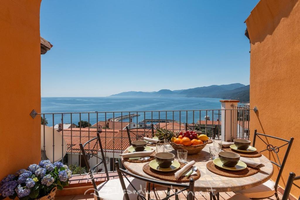 Una mesa con un bol de fruta en un balcón. en CASA CON VISTA MARE, en Cala Gonone