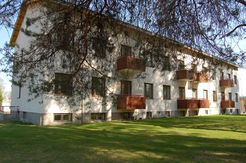 un grand bâtiment blanc avec de l'herbe devant lui dans l'établissement Apartementos Saukkohaka, à Ristijärvi