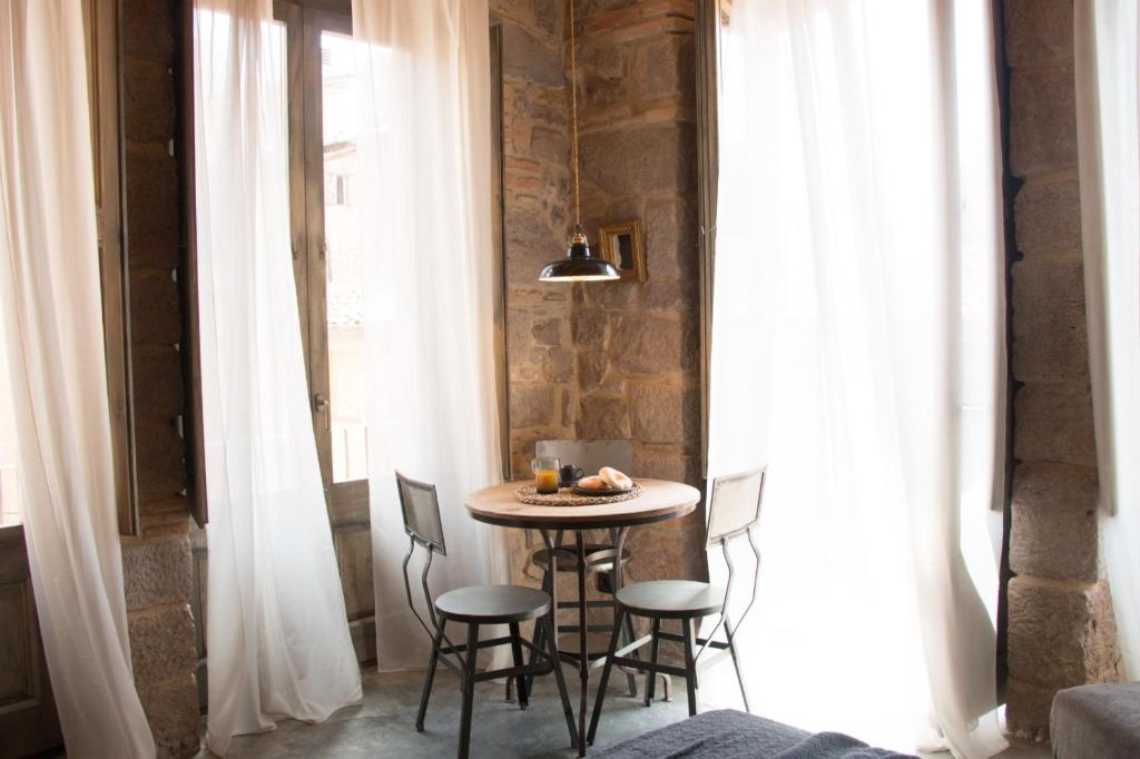 a small table in the corner of a room with white curtains at Casa Boutique nº 24 in Cardona