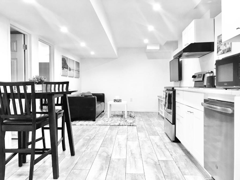 uma cozinha com uma mesa e uma cadeira num quarto em Modern 1BR Basement Suite With Parking em Innisfil