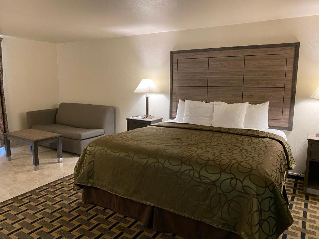 a hotel room with a bed and a chair at Motel In The Pines in Munds Park