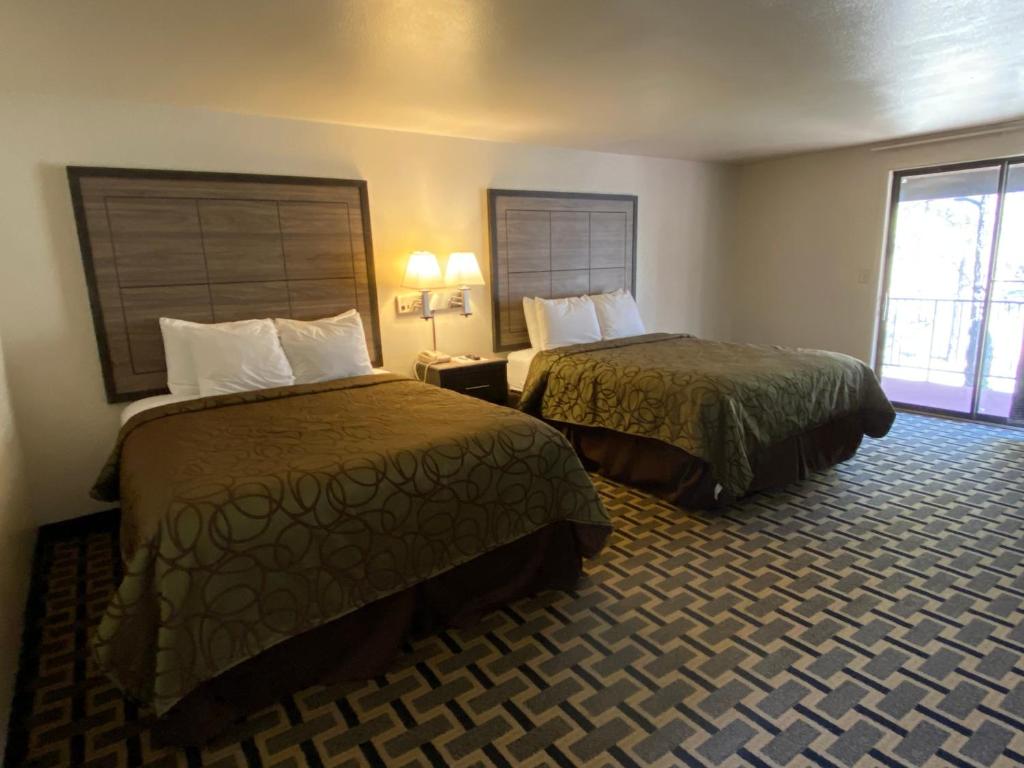 a hotel room with two beds and a window at Motel In The Pines in Munds Park