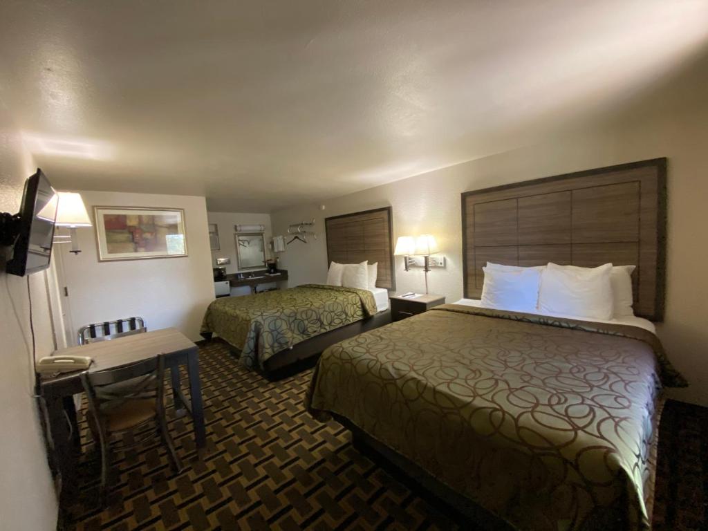a hotel room with two beds and a table at Motel In The Pines in Munds Park