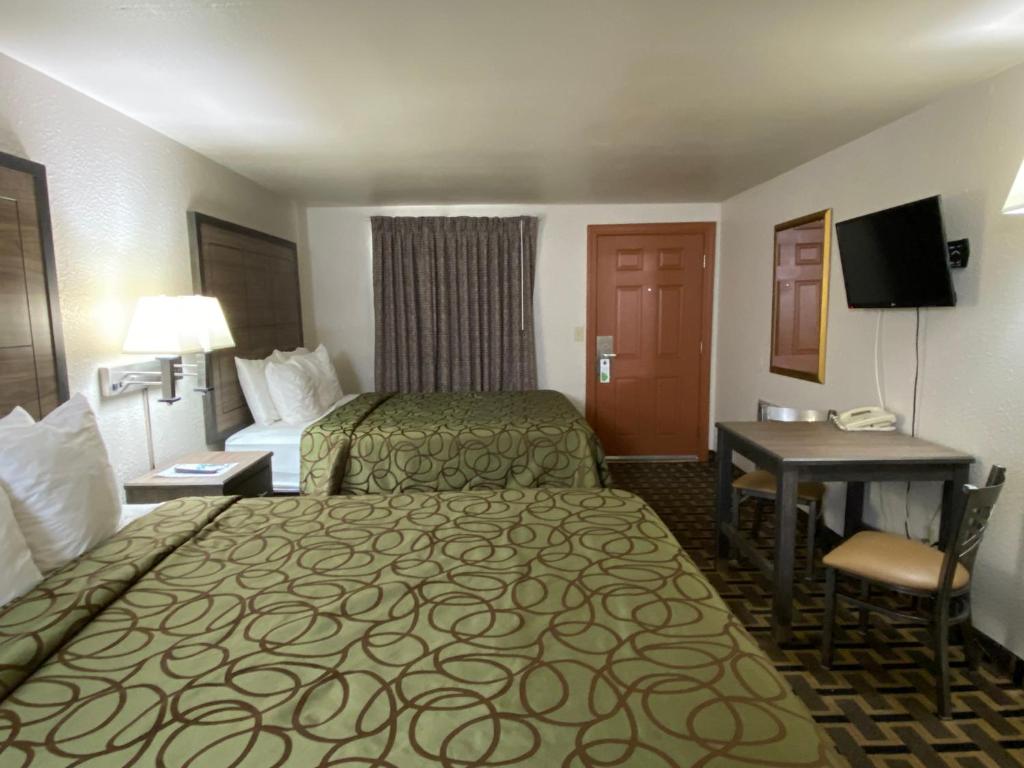 a hotel room with two beds and a desk at Motel In The Pines in Munds Park