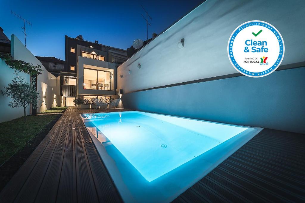 a swimming pool in front of a house at Bom Jardim Apartments in Porto
