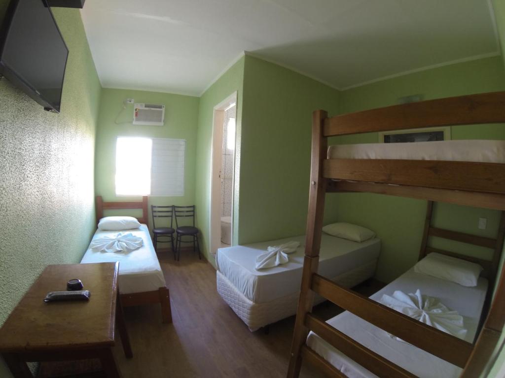 a small room with two bunk beds and a table at Hotel Paris in Jundiaí