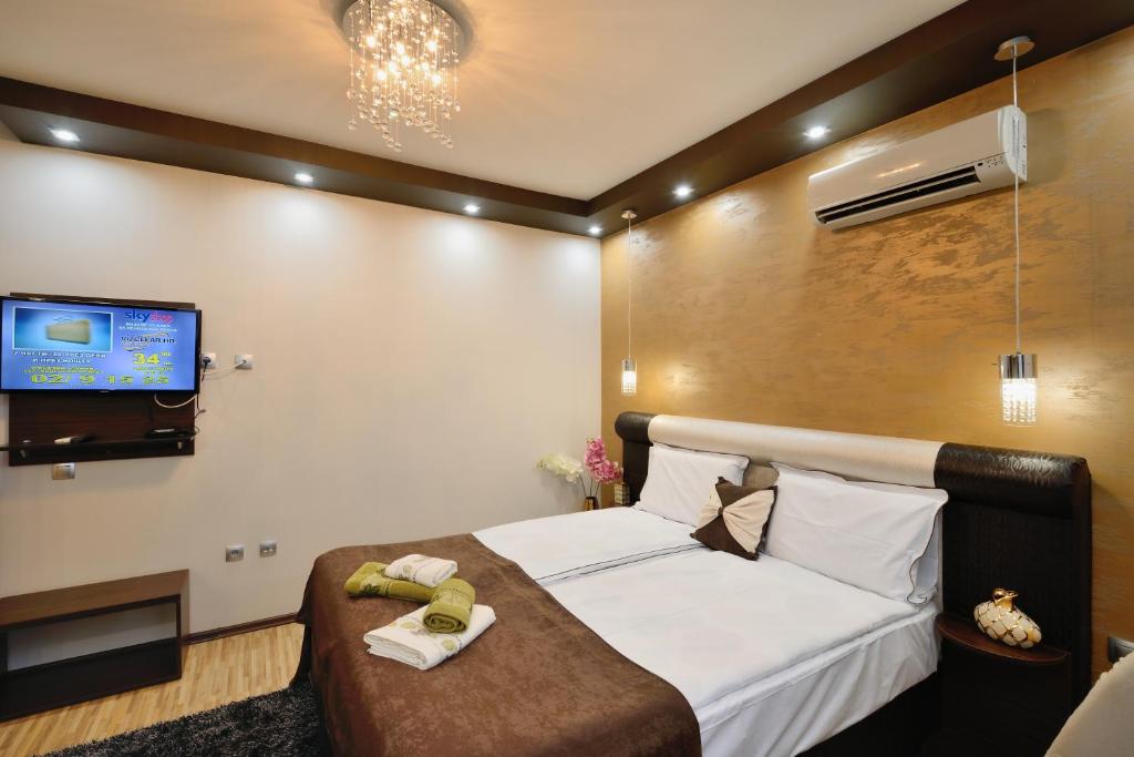 1 dormitorio con 1 cama y TV de pantalla plana en Fantasy Apartaments and studios Avenue комплекс Фантазия Хисаря en Hisarya