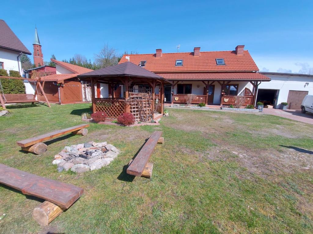 a yard with benches and a fire pit in front of a house at Apartamenty Kołczewo in Kołczewo