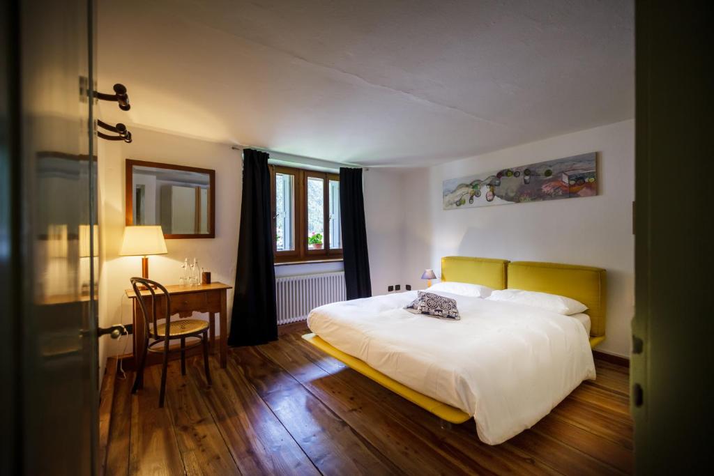 a bedroom with a bed and a table and a chair at La Pita Guesthouse in Cancellade