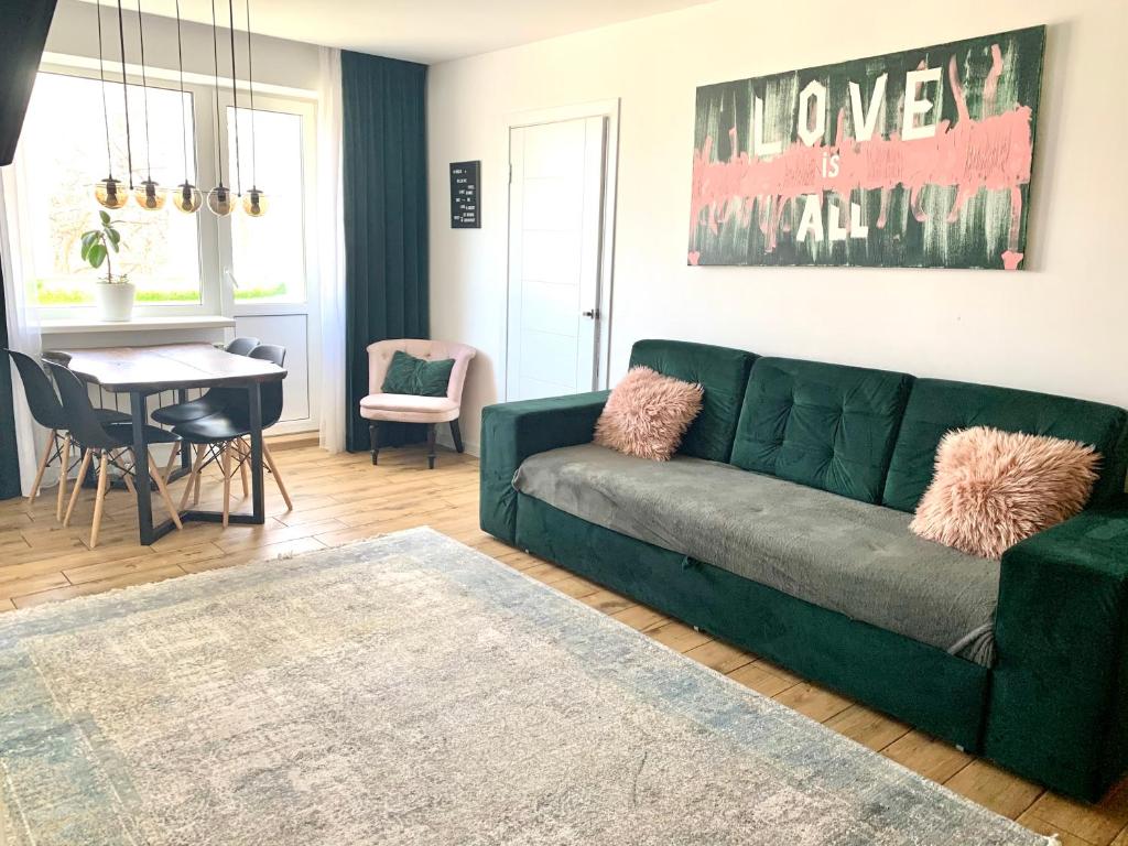 - un salon avec un canapé vert et une table dans l'établissement Park Lake Апартаменти Центр, à Ternopil