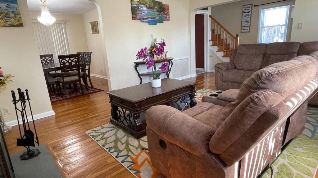 uma sala de estar com um sofá e uma mesa em Governors Villa Long Island em Hempstead