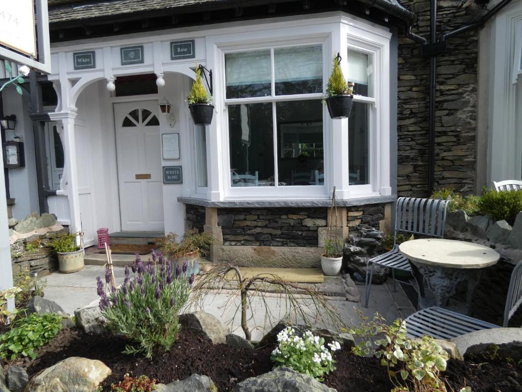 a house with a table and chairs and a window at White Rose in Windermere