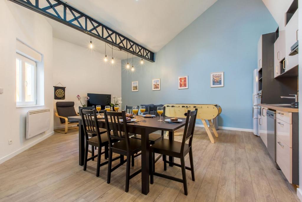 - une salle à manger et une cuisine avec une table et des chaises dans l'établissement Le Flamand, jeux en bois déco du nord!, à Tourcoing