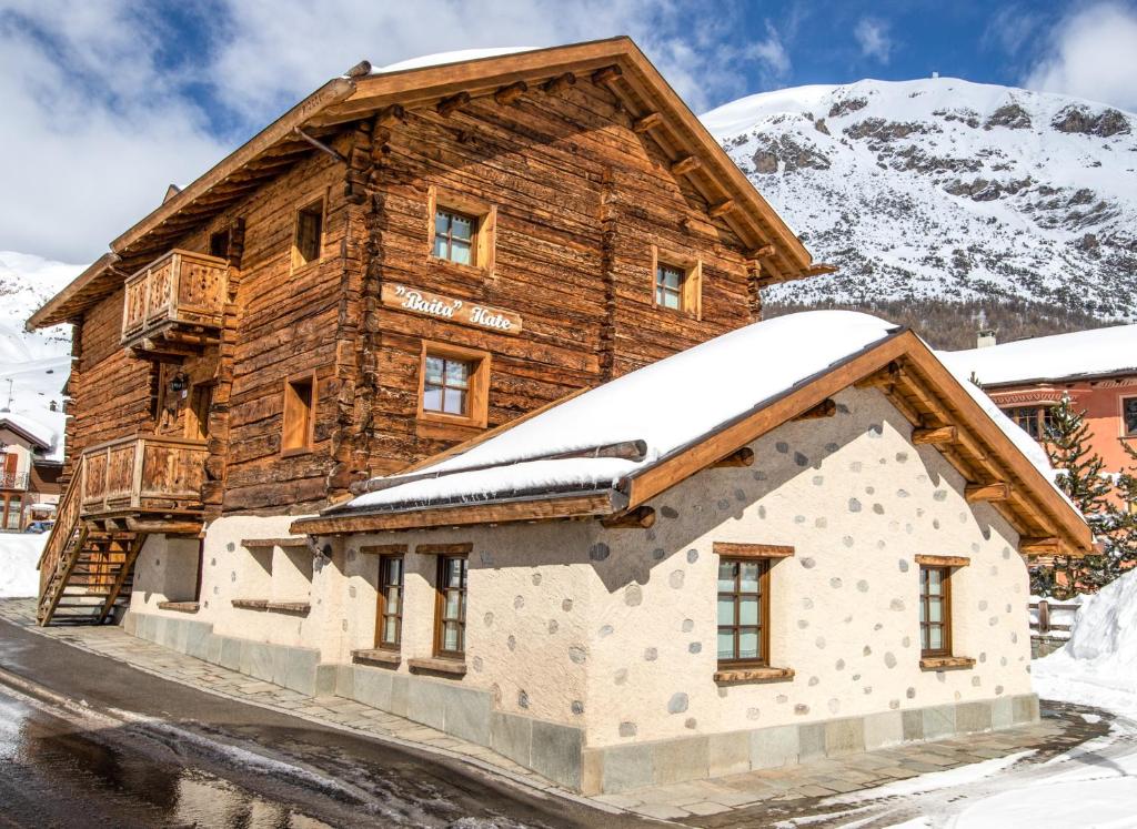 a log cabin with snow on the roof at Baita Kate in Livigno