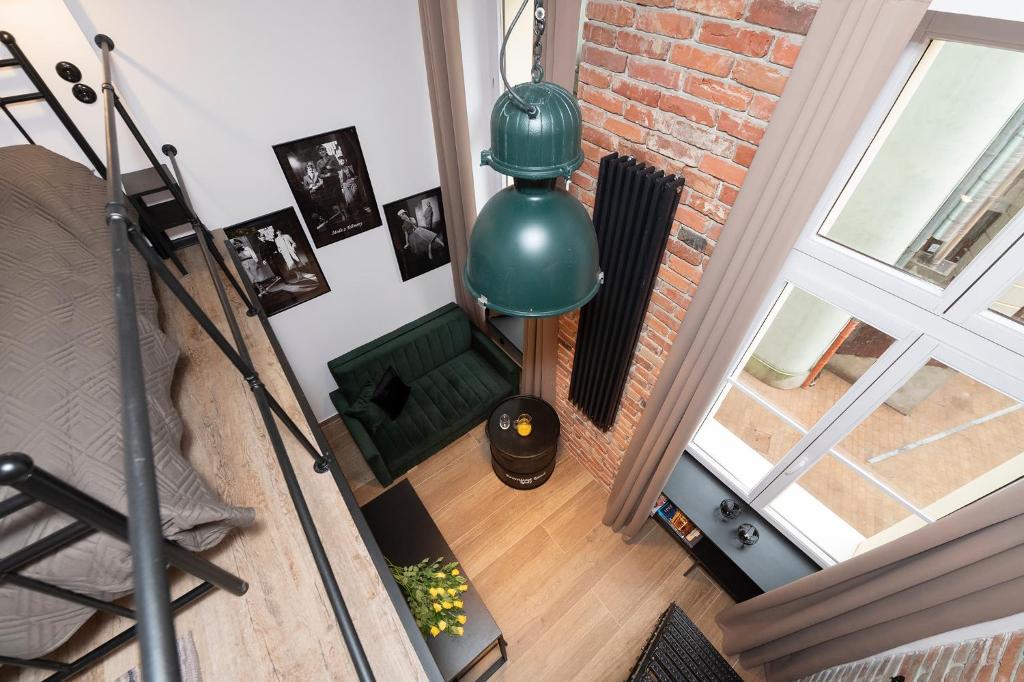 een woonkamer met een groene lamp bij Promised Land - Piotrkowska 37 in Łódź
