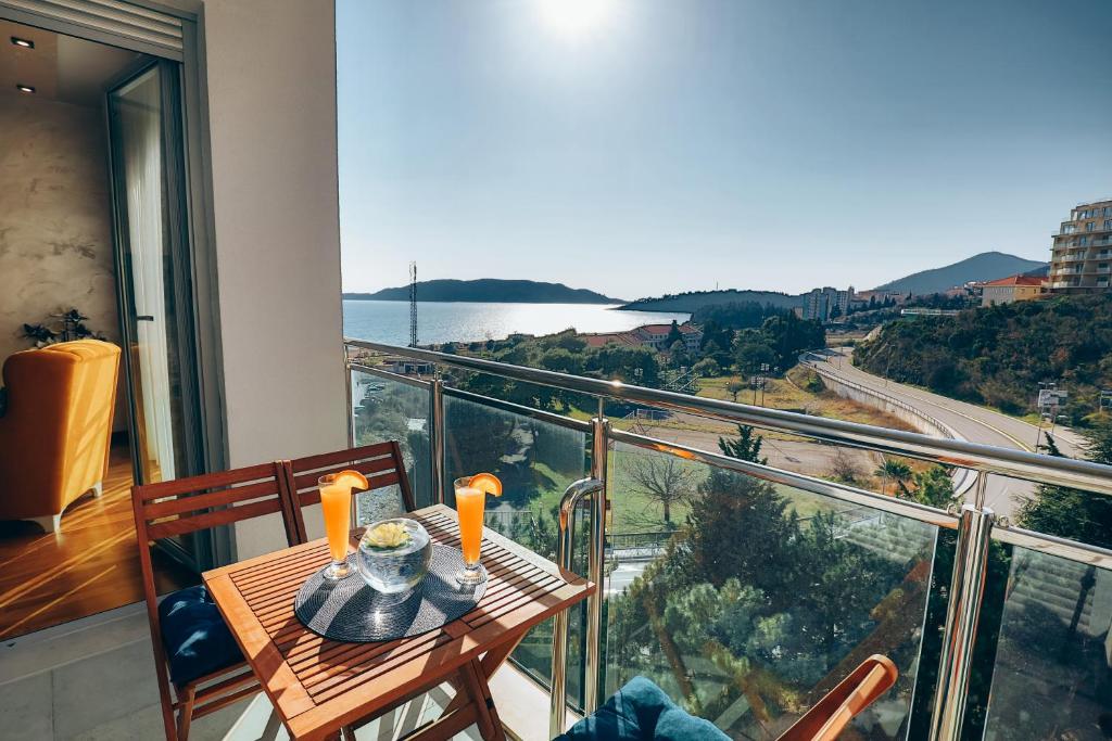 a balcony with a table and a view of the water at S&S Apartment Becici in Budva