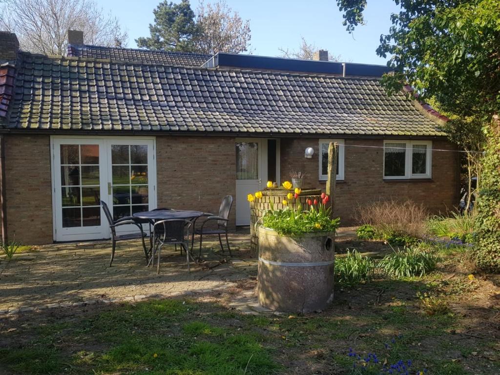 mały ceglany dom ze stołem i krzesłami w obiekcie Het Karnhuis w mieście Schoondijke