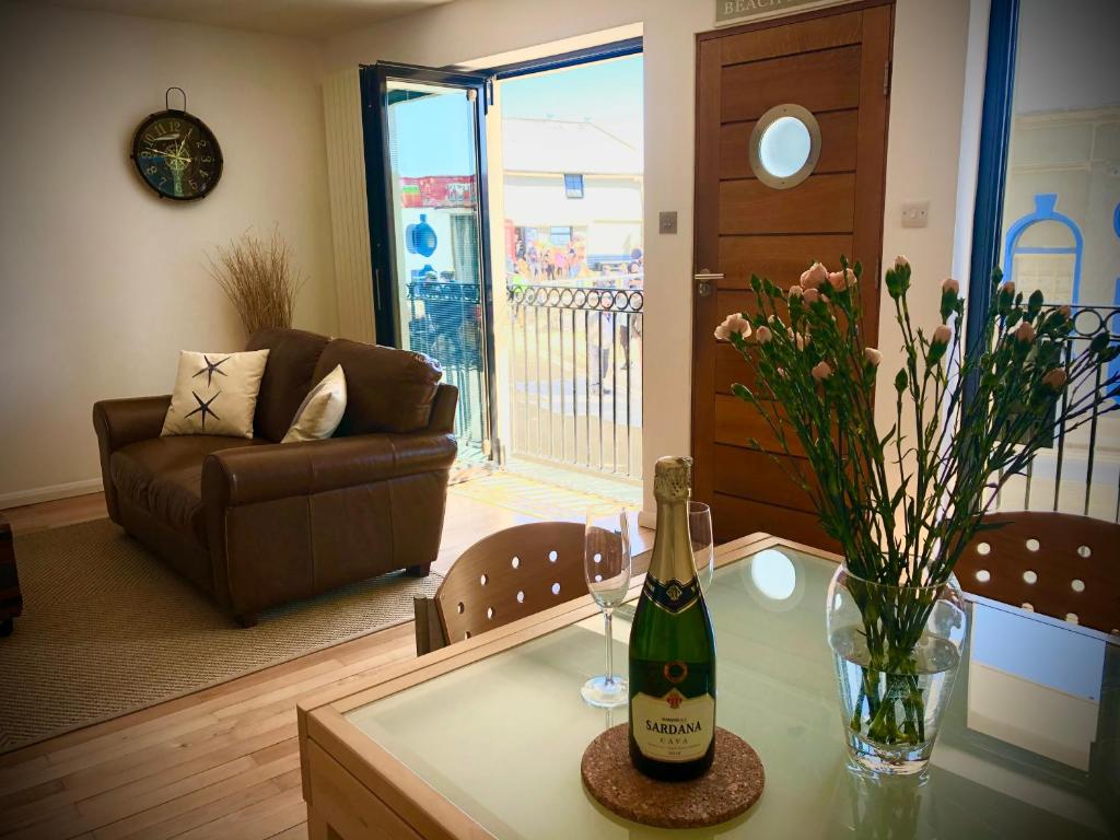 a bottle of champagne on a table in a living room at The Beach House Broadstairs in Broadstairs