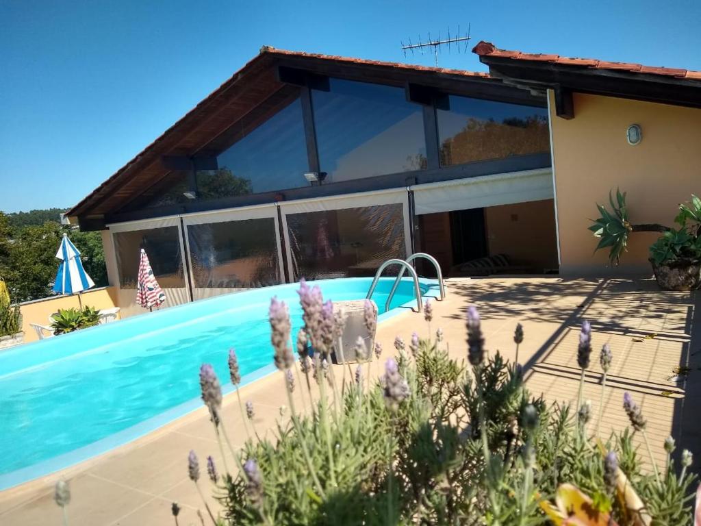 a villa with a swimming pool in front of a house at Bosque Urbano - Cobertura Privativa com Lareira e Piscina in Bom Princípio