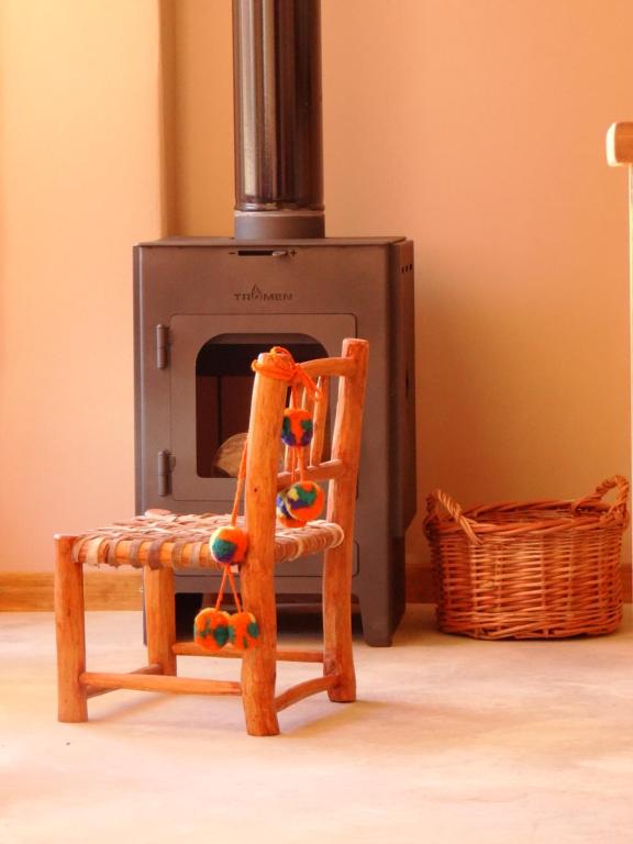 a wooden chair sitting in front of a stove at Tierra Quebrada Cabañas in Purmamarca