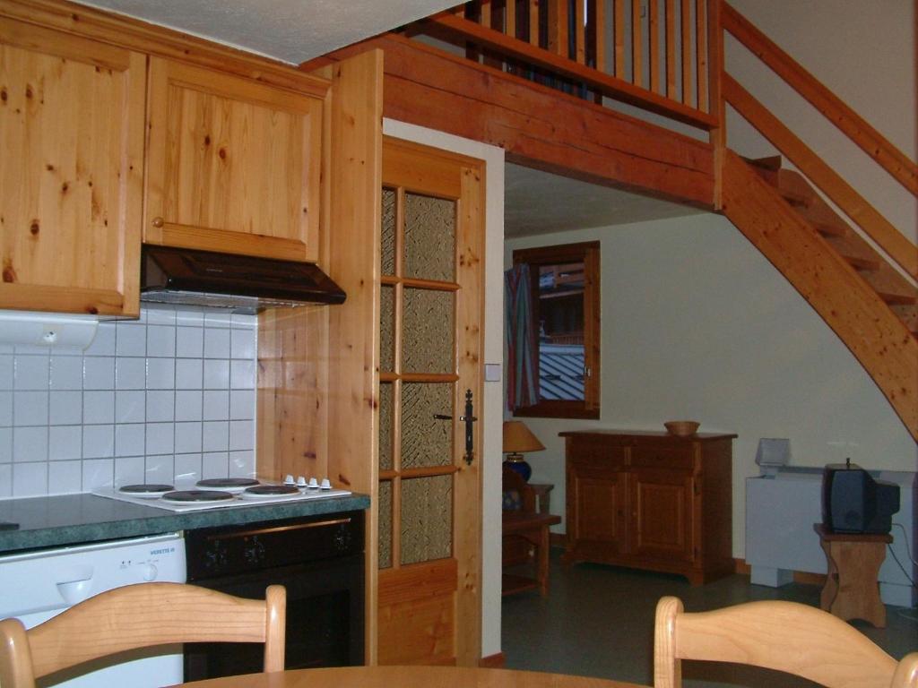 a kitchen with a staircase leading up to a loft at Alpes Roc in Pralognan-la-Vanoise