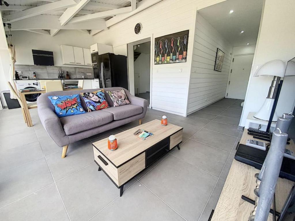 ein Wohnzimmer mit einem Sofa und einem Couchtisch in der Unterkunft Pop Up SXM - Anse Marcel beach - wifi 200Mbps in Anse Marcel 