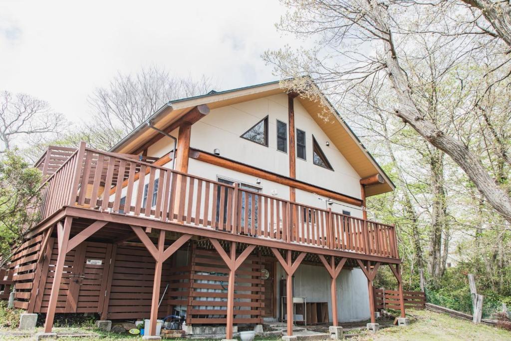une maison avec une grande terrasse sur le côté dans l'établissement Relaxing Log Cabin IZU HOUSE- Vacation STAY 85769, à Itō