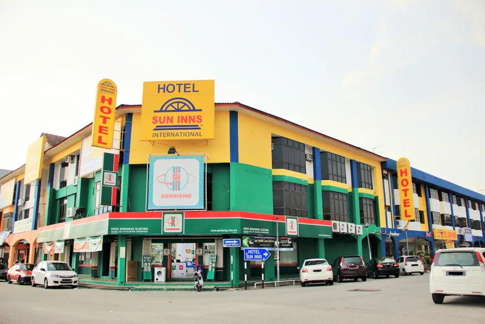 a hotel with cars parked in a parking lot at Sun Inns Hotel Sitiawan in Sitiawan