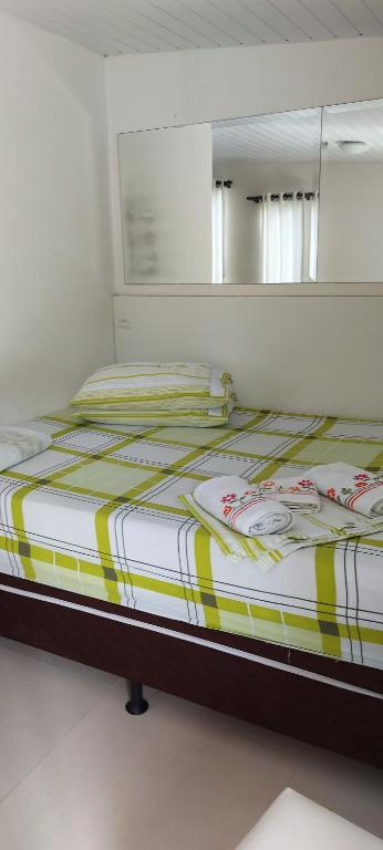 a bedroom with a large bed with a mirror at Quarto em Itajaí SC com banheiro e cozinha privativo estilo loft in Itajaí