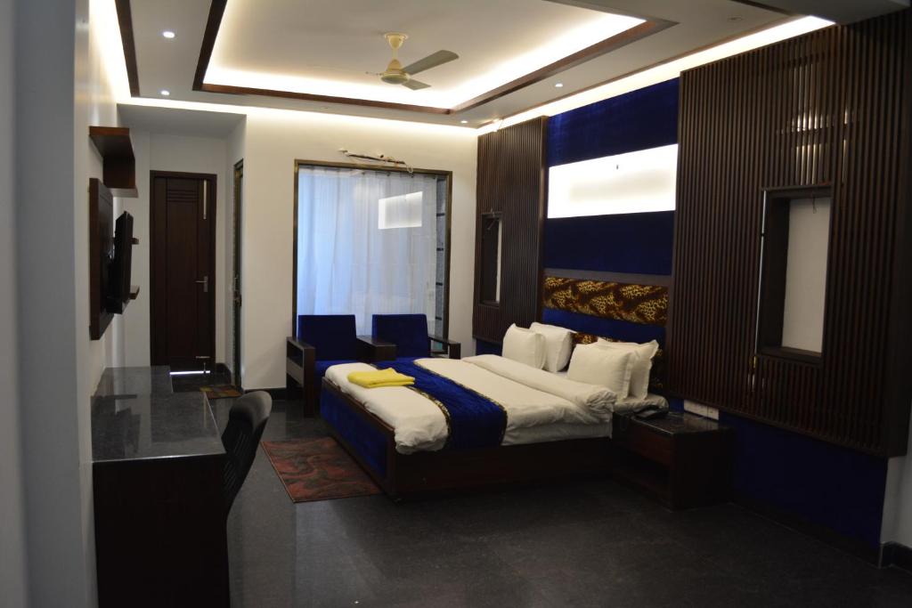 a hotel room with a bed with blue and white sheets at JJK Rukmini Vilas Hotel & Banquet in Muzaffarpur