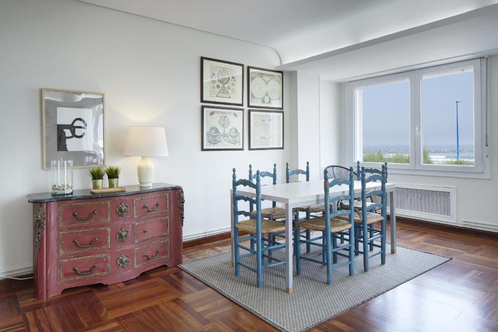 una sala da pranzo con tavolo, sedie e finestra di Iraun - Basque Stay a San Sebastián