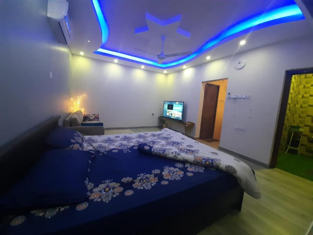 Un dormitorio con una cama con una luz azul. en Al Romaan villa, en Sayq