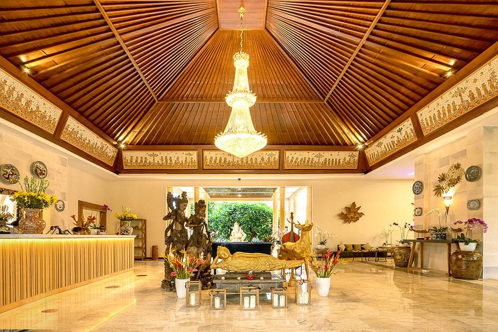 uma grande sala de estar com um tecto com um lustre em New Sunari Lovina Beach Resort em Lovina