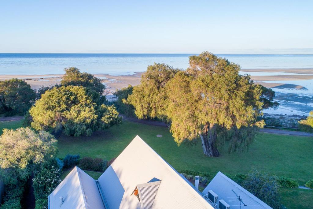 an aerial view of a house with trees and the ocean at Whalers Cove Villas in Dunsborough