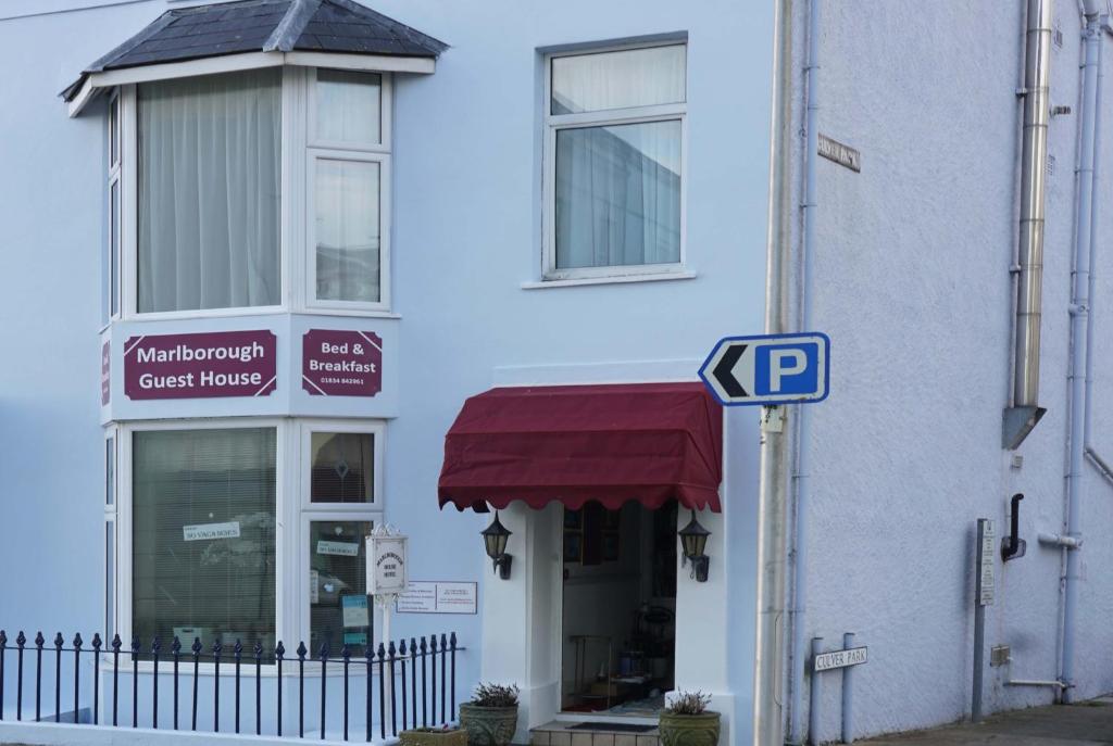 un letrero de la calle frente a un edificio blanco en Marlborough Guest House B & B, en Tenby