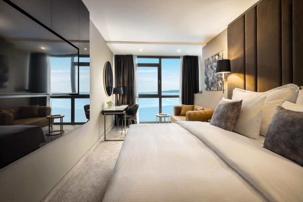 a bedroom with a large bed and a living room at Grand Hotel Adriatic in Opatija