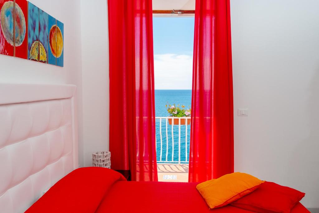 um quarto com um sofá vermelho e uma janela em Donna Giulia em Amalfi