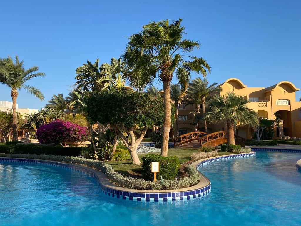 a swimming pool with palm trees in a resort at Sharm Grand Plaza Resort - Families and Couples Only in Sharm El Sheikh