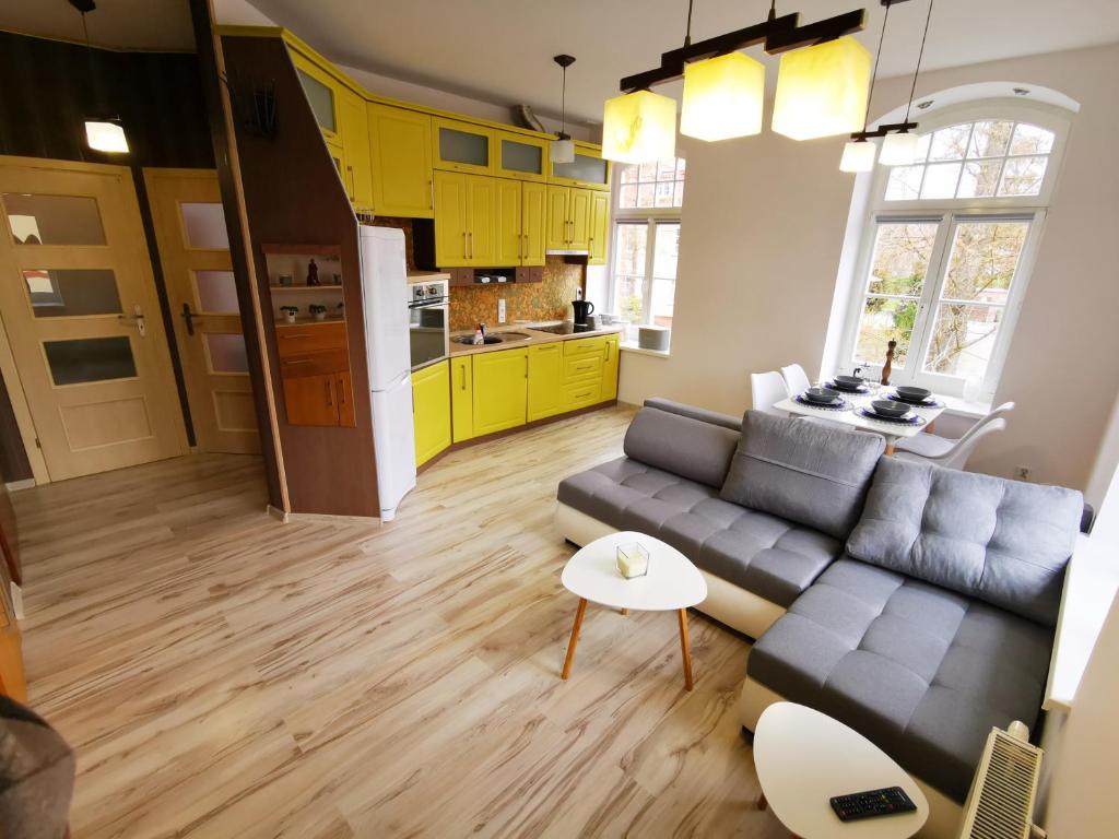 a living room with a couch and a kitchen at Apartament Kuba in Mrągowo