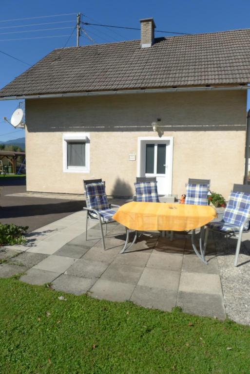 eine Terrasse mit einem Tisch und Stühlen vor einem Haus in der Unterkunft Ferienwohnung Kusternik in Velden am Wörthersee