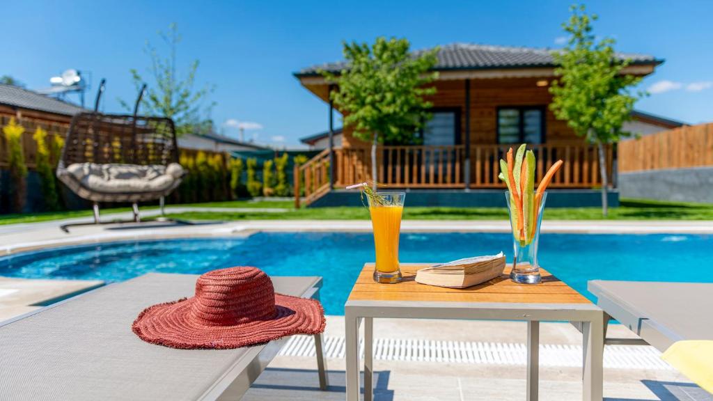 Un chapeau sur une table à côté d'une piscine dans l'établissement Villa Cedrus 1-2-3-4-5, à Fethiye