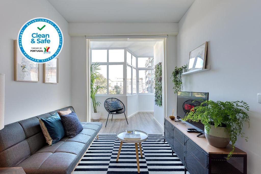 een woonkamer met een bank en een tafel bij DA'HOME - Boavista Brightful Apartment in Porto