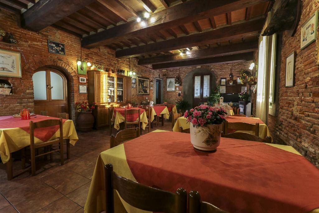 un restaurante con mesas y sillas con manteles rojos y amarillos en Agriturismo il Poggetto, en Torre